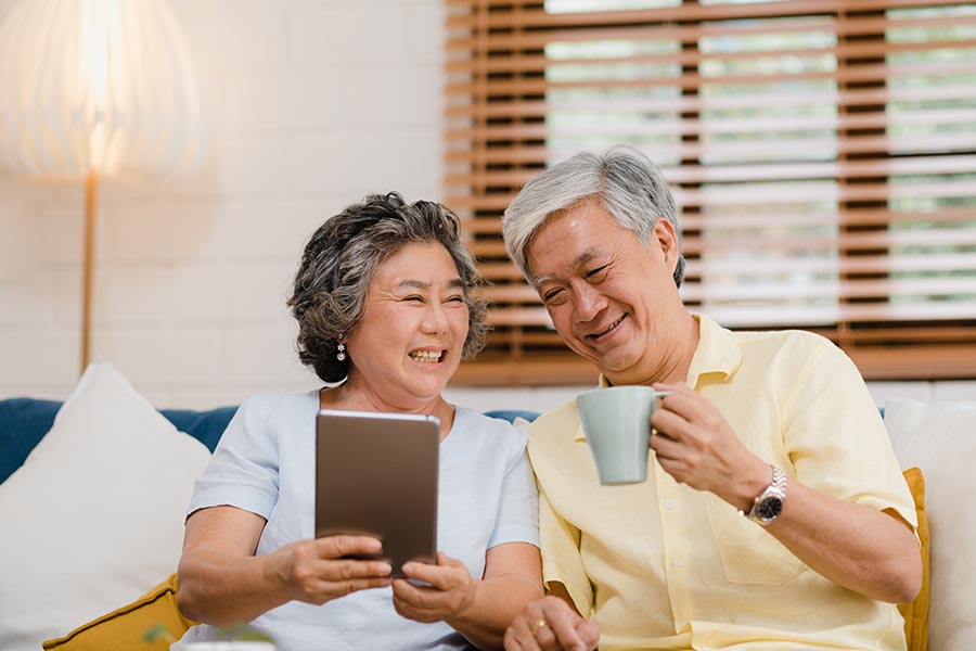 Blog - Senior Couple Reading a Tablet and Drinking Coffee in Their Living Room